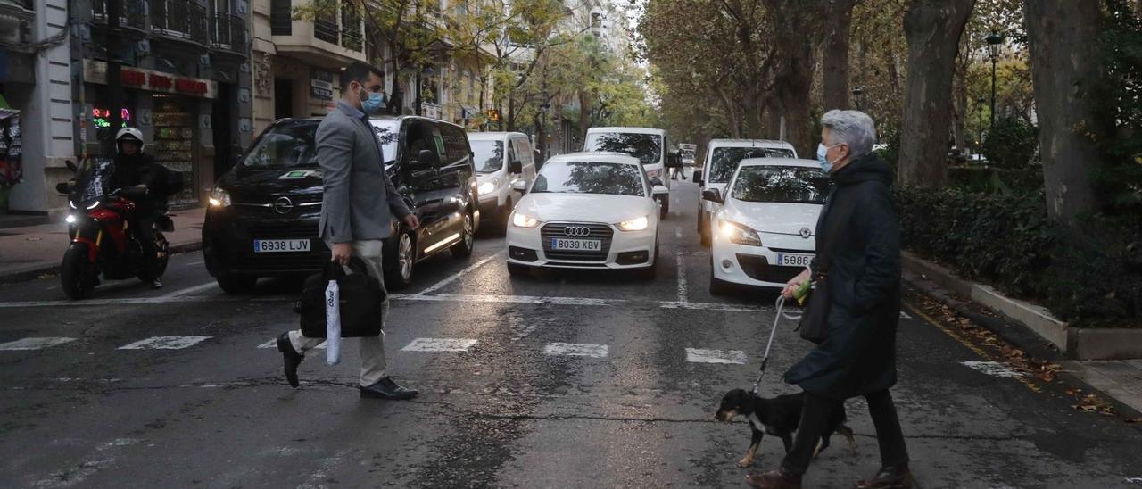 Varios vehículos esperan con
 sus motores en marcha en un
 semáforo en rojo en el centro
 de València.  JM LÓPEZ | JM LÓPEZ