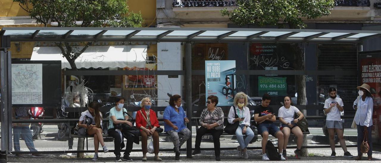 Usuarios del autobús urbano esperan a la sombra en una parada de la plaza San Miguel.  | ANDREEA VORNICU
