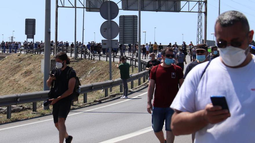 Pla obert dels treballadors de Nissan tallant el carrer 3 de la Zona Franca en direcció a la Gran Via.