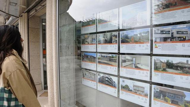 Una joven observa la oferta de una inmobiliaria en Lalín.