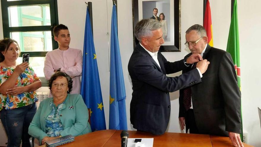 Marcelino Martínez impone la insignia a José María Álvarez en presencia de su hermana (sentada).