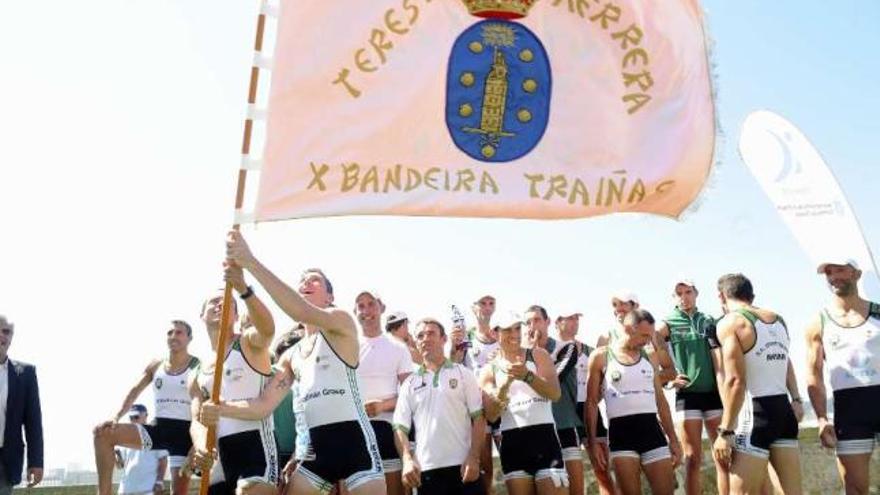 La tripulación de Samertolaméu ondea la bandera ganada ayer. // 13fotos