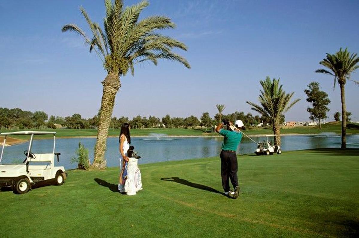 Jugar al golf entre palmeras frente al mar