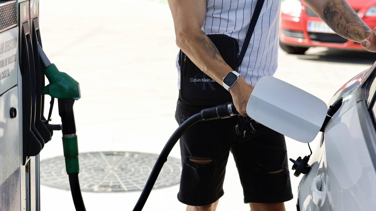 Un hombre pone gasolina en una estación de servicios.