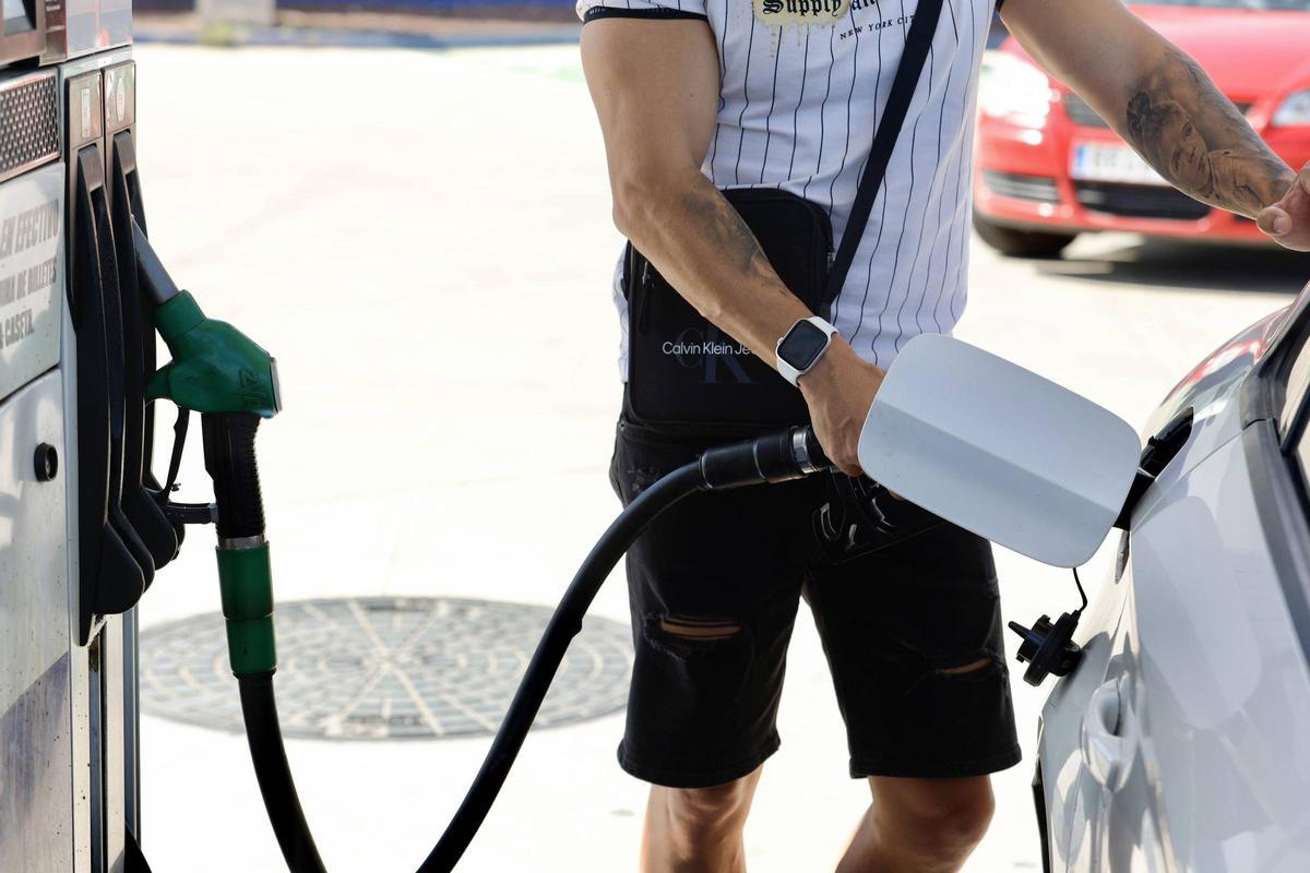 Un hombre pone gasolina en una estación de servicios.