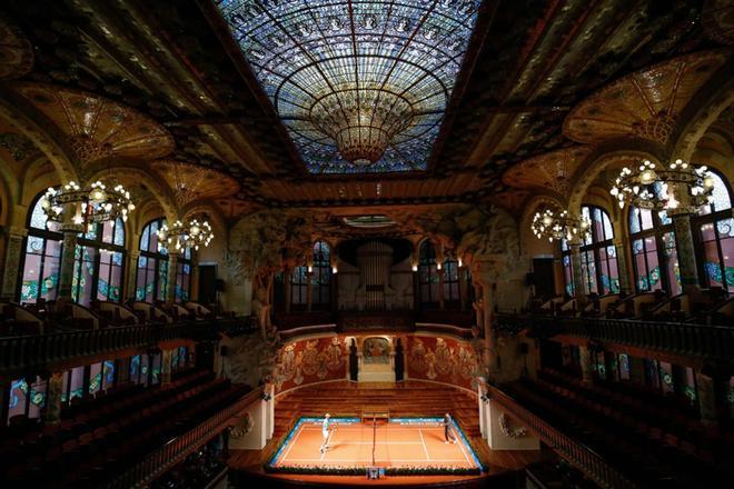 Rafael Nadal (L) juega contra Kei Nishikori durante un partido de tenis promocional en el Palau de la Música en Barcelona el 22 de abril de 2019 al margen del torneo de tenis ATP Open de Barcelona.