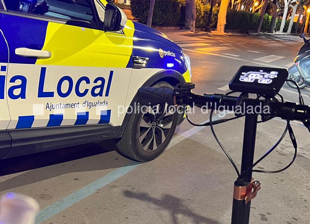 Imatge del patinet elèctric del detingut al costat d'un cotxe dela Policia Local d'Igualada