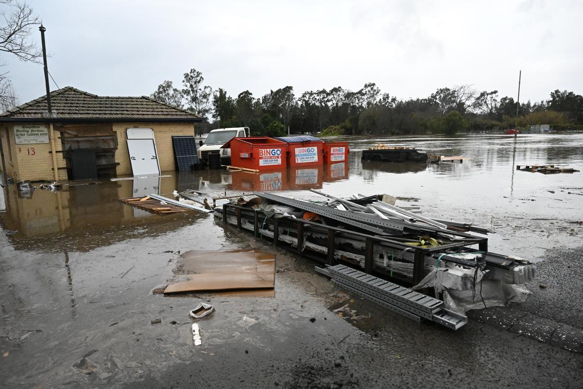 Los contenedores de basura se ven inundados por las aguas de la inundación en Camden, en el suroeste de Sídney, Australia ,obligando a la evacuación de miles de residentes.