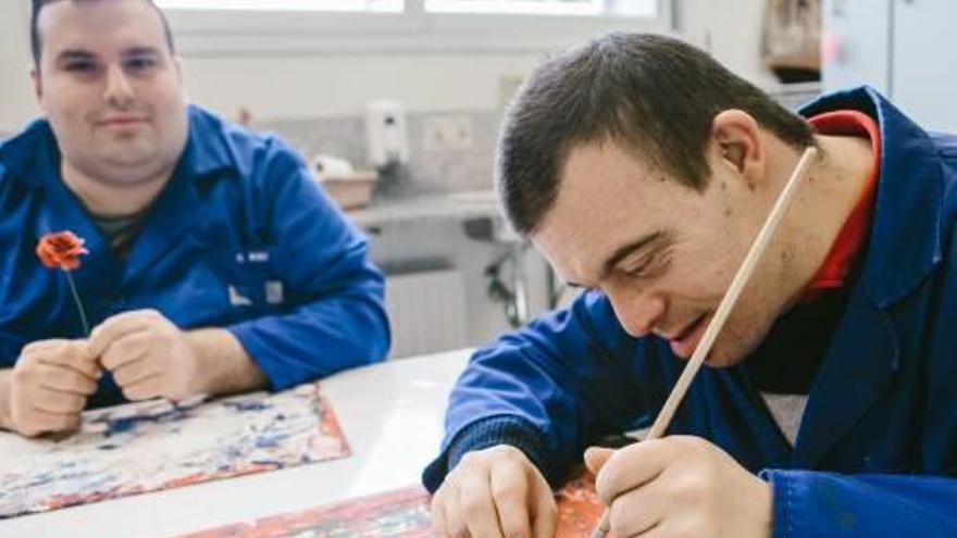 Dos usuaris de la fundació, treballant en l&#039;elaboració de roses.