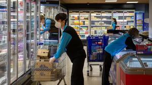 Trabajadores en un supermercado Caprabo.