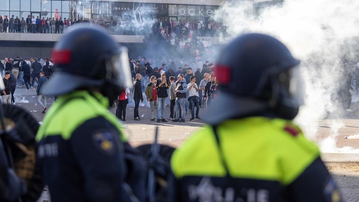 Policías antidisturbios vigilan a los ultras tras suspenderse el Ajax-Feyenoord.