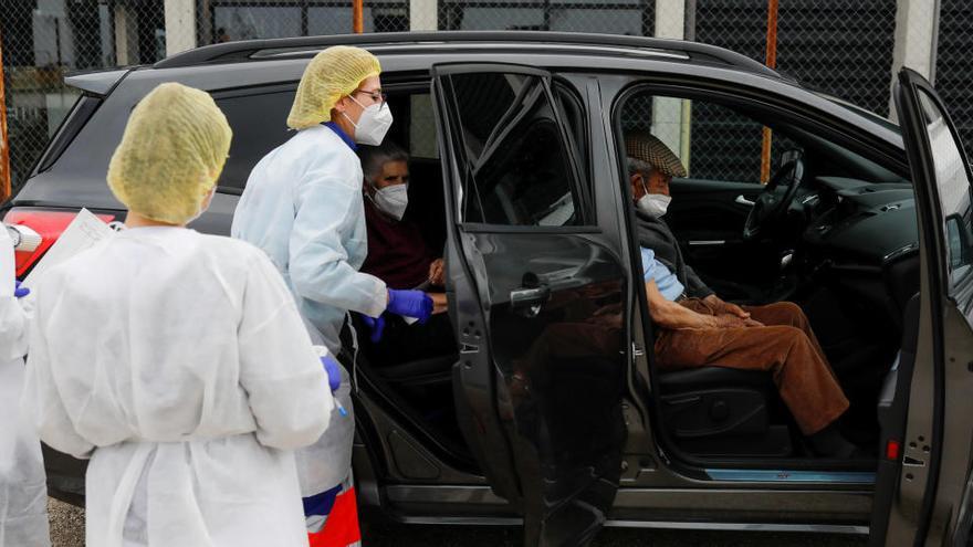 Una pareja de ancianos sentados en un coche tras recibir la vacuna en Ronda.