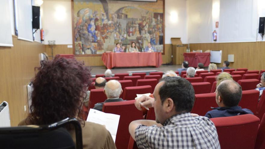 Dos alcaldes examinan una factura de Acuaes durante la asamblea ordinaria de la Mancomunidad de la ETAP de Benavente y Los Valles celebrada anoche en La Encomienda.