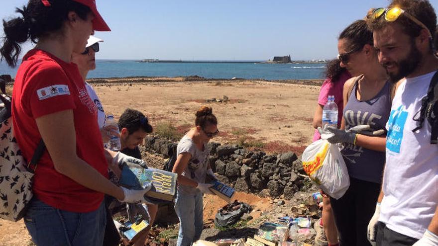 Voluntarios, ayer, junto a los libros hallados en el Islote del Francés.