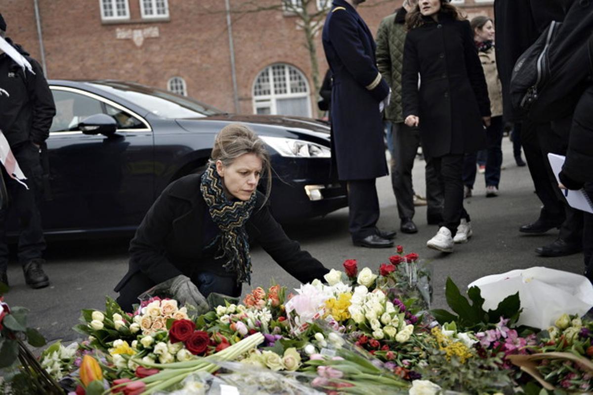 Una dona diposita flors a Oesterbro, un dels dos escenaris on va actuar el terrorista.