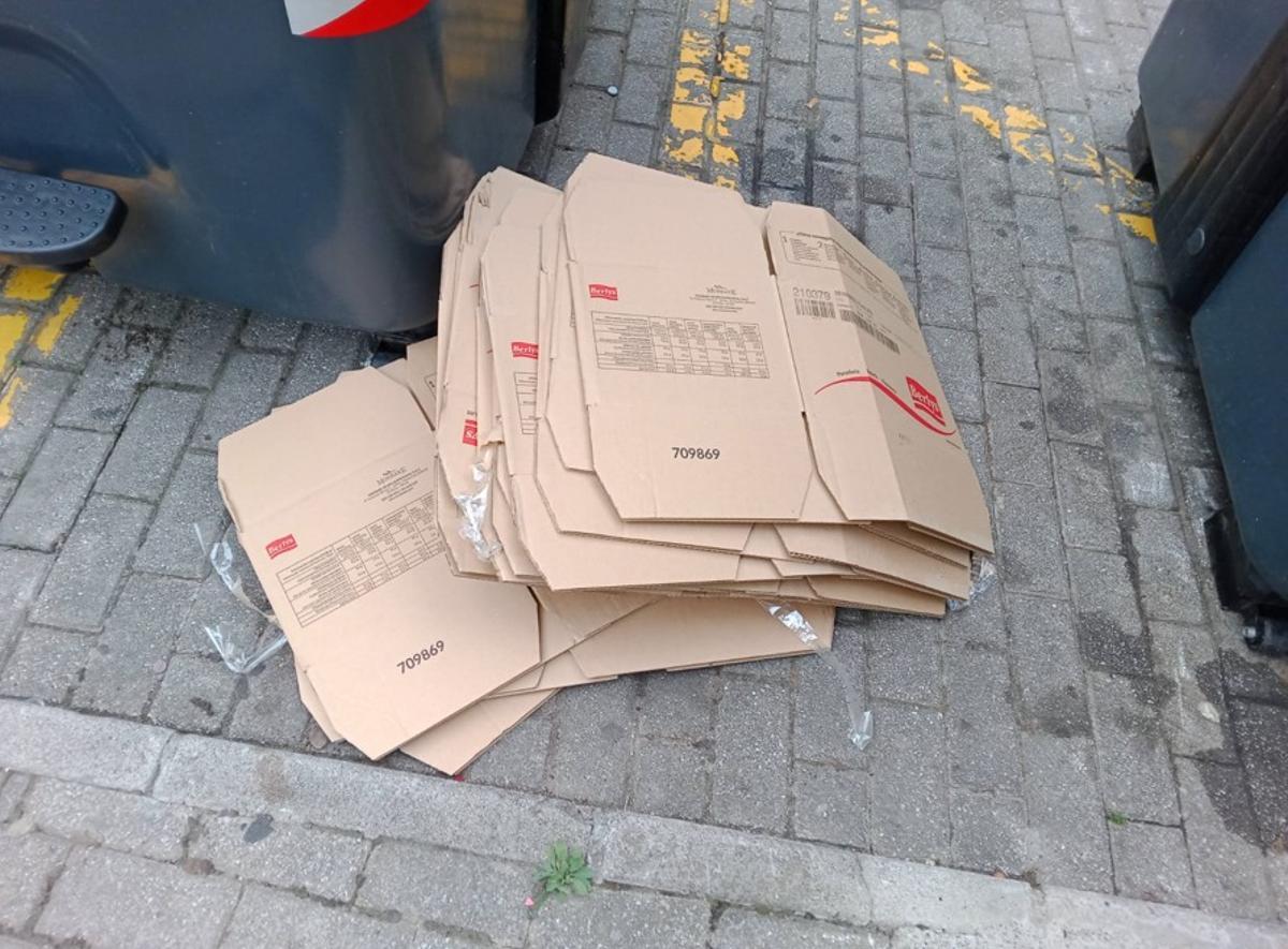 Cartones en el exterior de contenedores en el centro de la villa.