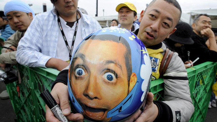 Un fan japonés muestra un casco con el rostro del piloto italiano de Moto GP Valentino Rossi