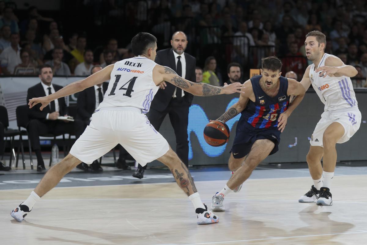 SEVILLA, 25/09/2022.- El jugador del Barcelona Nicolás Laprovittola (c) juega un balón entre Gabriel Deck (i) y Fabien Causeur, ambos del Real Madrid, durante la final de la Supercopa de baloncesto disputada este domingo en el pabellón de San Pablo, en Sevilla. EFE/Jose Manuel Vidal