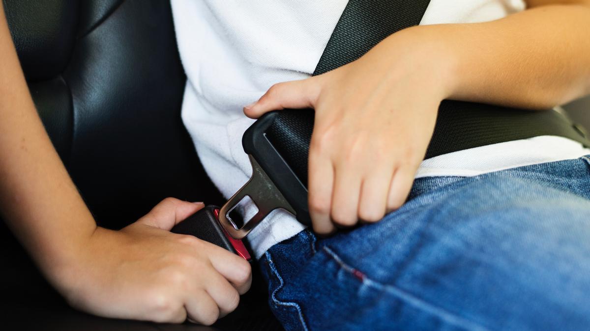 Una persona se abrocha el cinturón de seguridad en el coche
