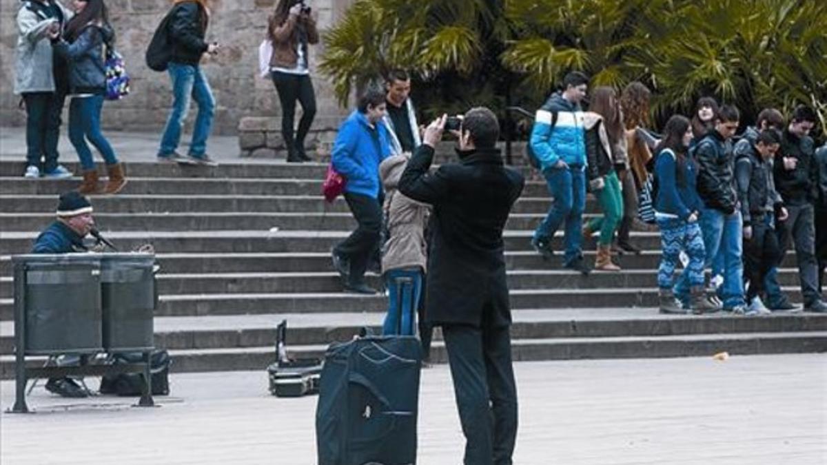 Un turista toma fotos de la Catedral de Barcelona, ayer, en un receso de su largo paseo por Ciutat Vella para encontrar su hotel.