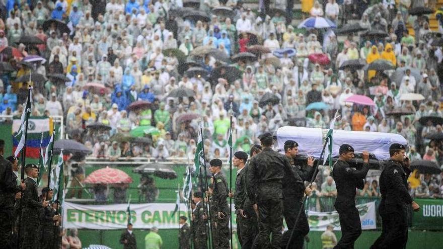 Miembros del ejército brasileño transportan el féretro de una de las víctimas. // Efe