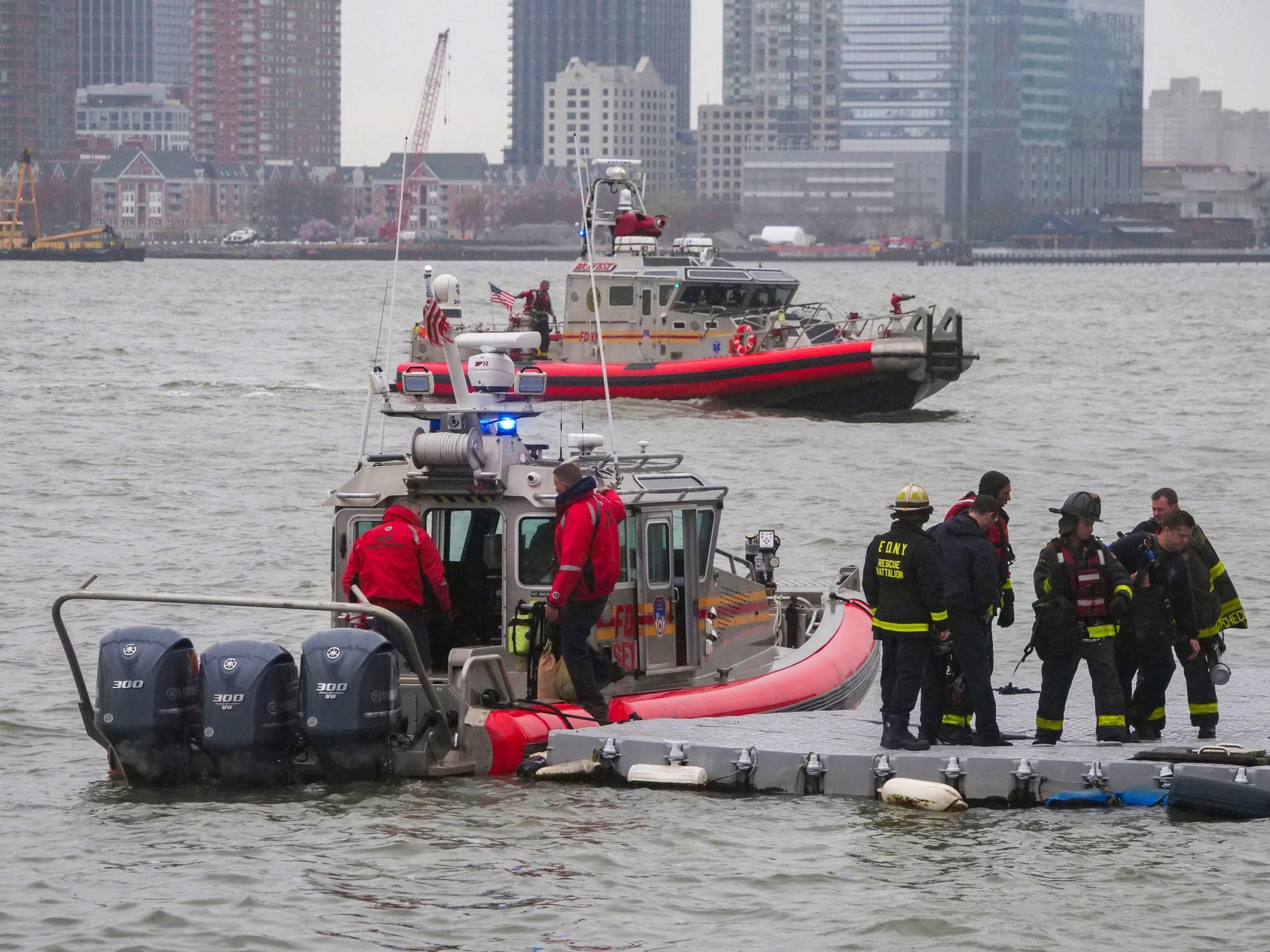 10 April 2025, US, New York: NYFD divers return to Pier 40 on the NYC waterfront as rescue boats continue searching for the downed tourist helicopter in the Hudson River off Jersey City. Six people died in the fatal crash.