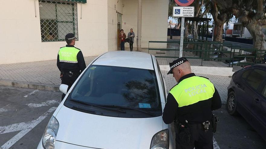 Un agente comprueba una tarjeta de estacionamiento para personas con movilidad reducida.