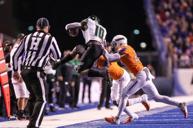 El receptor abierto Drake Stallworth # 10 de los Hawaii Rainbow Warriors es eliminado por la seguridad Kekaula Kaniho # 28 de los Boise State Broncos durante la primera mitad de la acción.