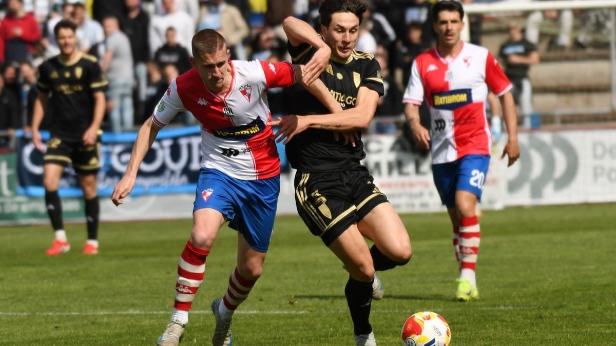 Una pugna por un balón entre los jugadores del Arosa y el Compostela