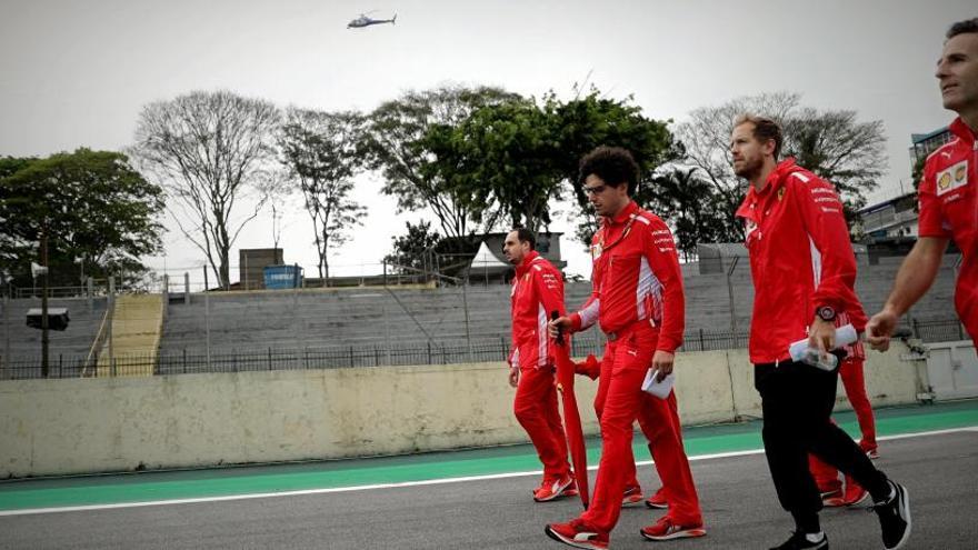 Vettel y los mecánicos de Ferrari caminan por el circuito de Interlagos.