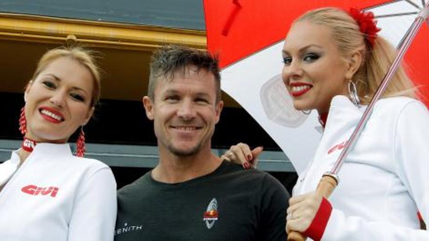 El austríaco Felix Baumgartner, que rompió la barrera del sonido, junto a las azafatas en el pit-lane.