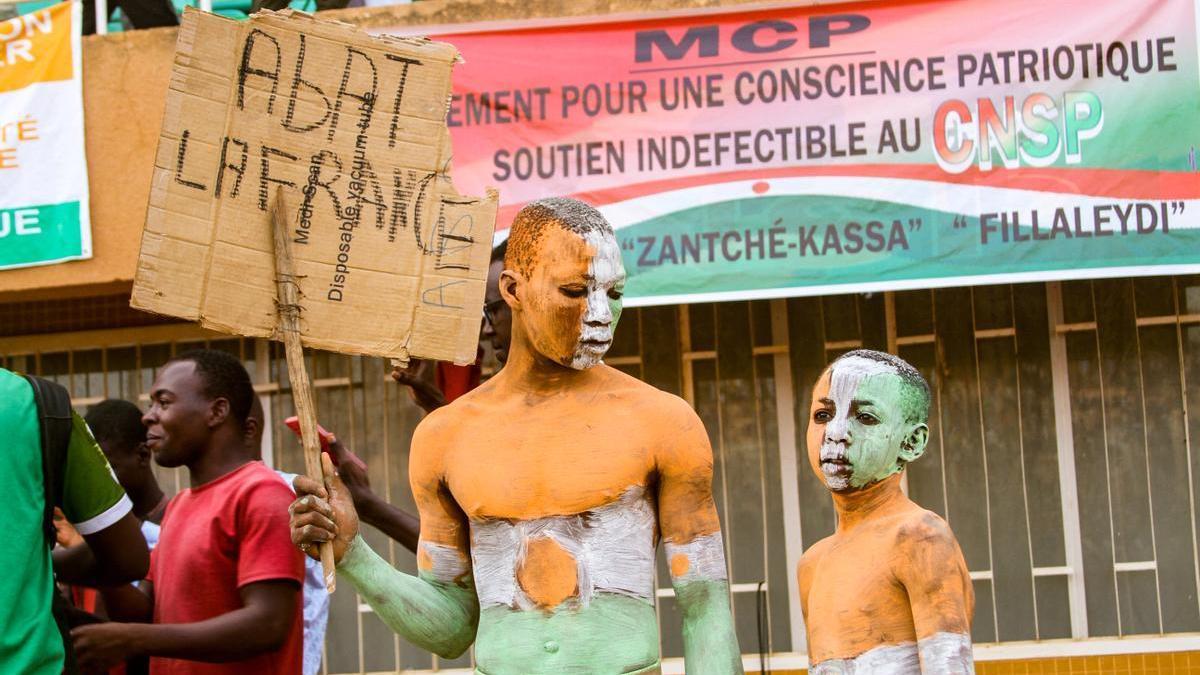 Un simpatizante de la junta militar de Níger muestra un cartel en el que se puede leer ’Abajo Francia’ en una manifestación de apoyo a los golpistas, en Niamey.