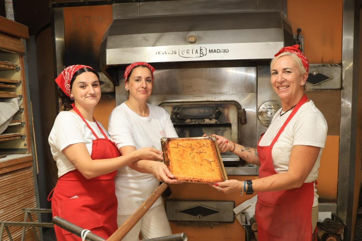 Trabajadoras del Horno Antiguo de Benimagrell muestran una coca amb tonyina recién sacada del horno.
