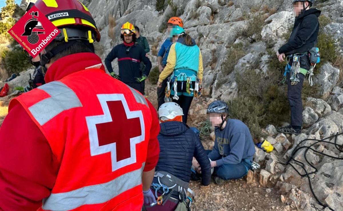 Rescatadores y otros escaladores junto a uno de los accidentados