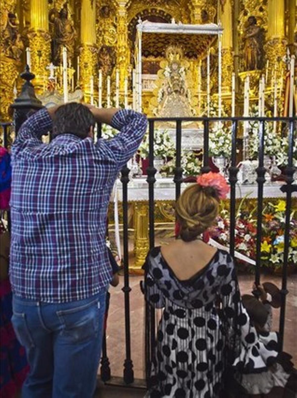 Una parella de ’rocieros’ observa la Verge del Rocío a l’ermita del poble d’Almonte, el 8 de juny.