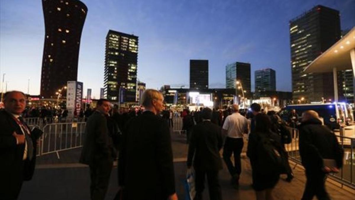 Asistentes al MWC abandonan las instalaciones de la feria.