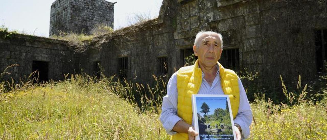 Luis Ferro, con su libro, ante la Torre y el Pazo de Guimarei.   | // BERNABÉ