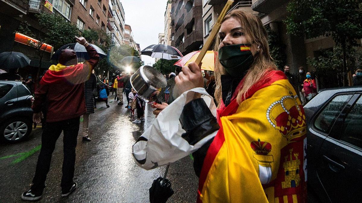 Una mujer golpea una cacerola en la calle de Núñez de Balboa de Madrid por la gestión de la crisis del coronavirus por parte del Gobierno, el 12 de mayo