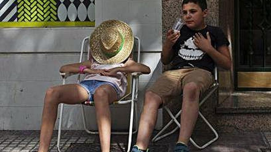 Dos niños se protegen del calor durante las horas centrales de este sábado.