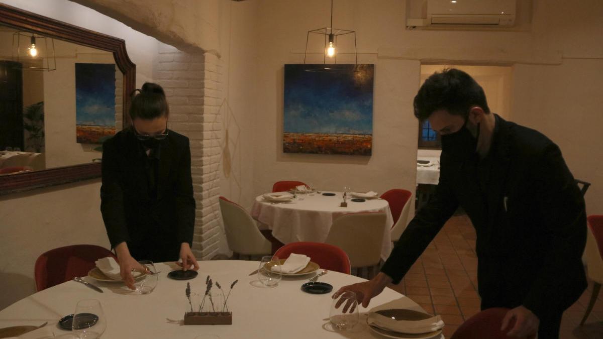 Dos cambrers de Cal Ros de Girona, preparant una taula.