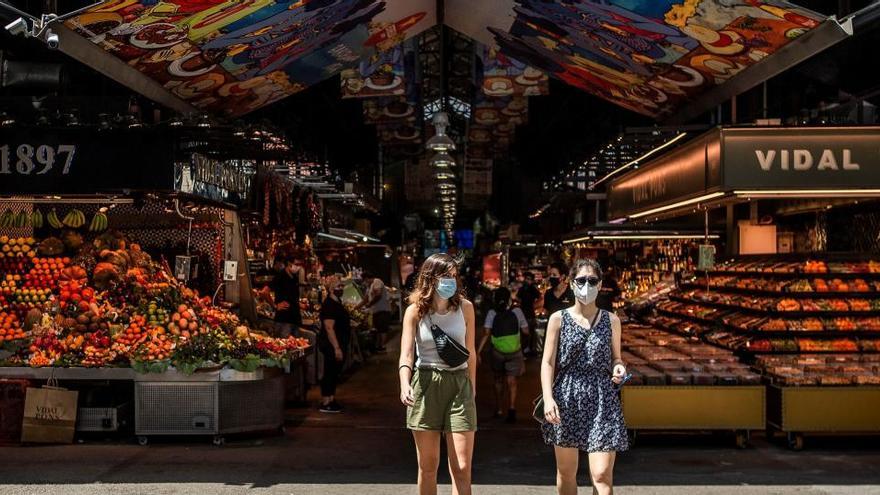 Dos visitants surten del mercat de la Boqueria de Barcelona