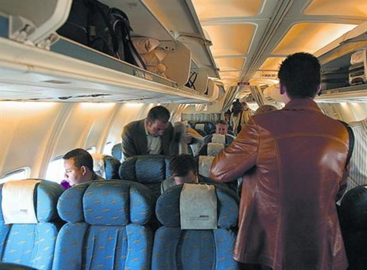 Diversos passatgers s’acomoden en un avió del pont aeri.