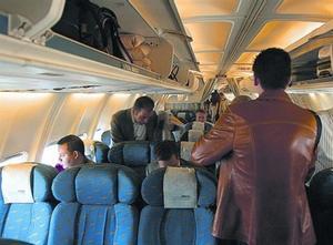 Varios pasajeros se acomodan en un avión del puente aéreo.