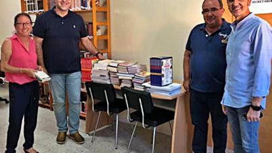 Autoridades provinciales y locales posan con el lote de libros