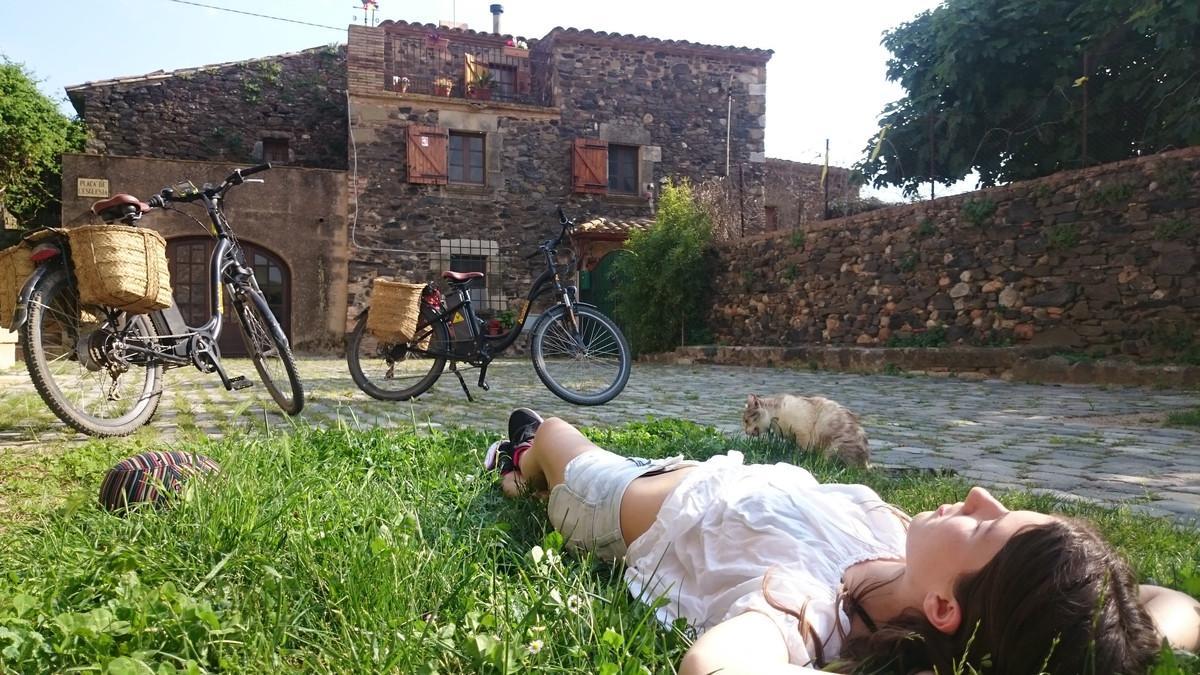 Una joven descansa en un momento de la ruta con bicicleta eléctrica por el Baix Empordà