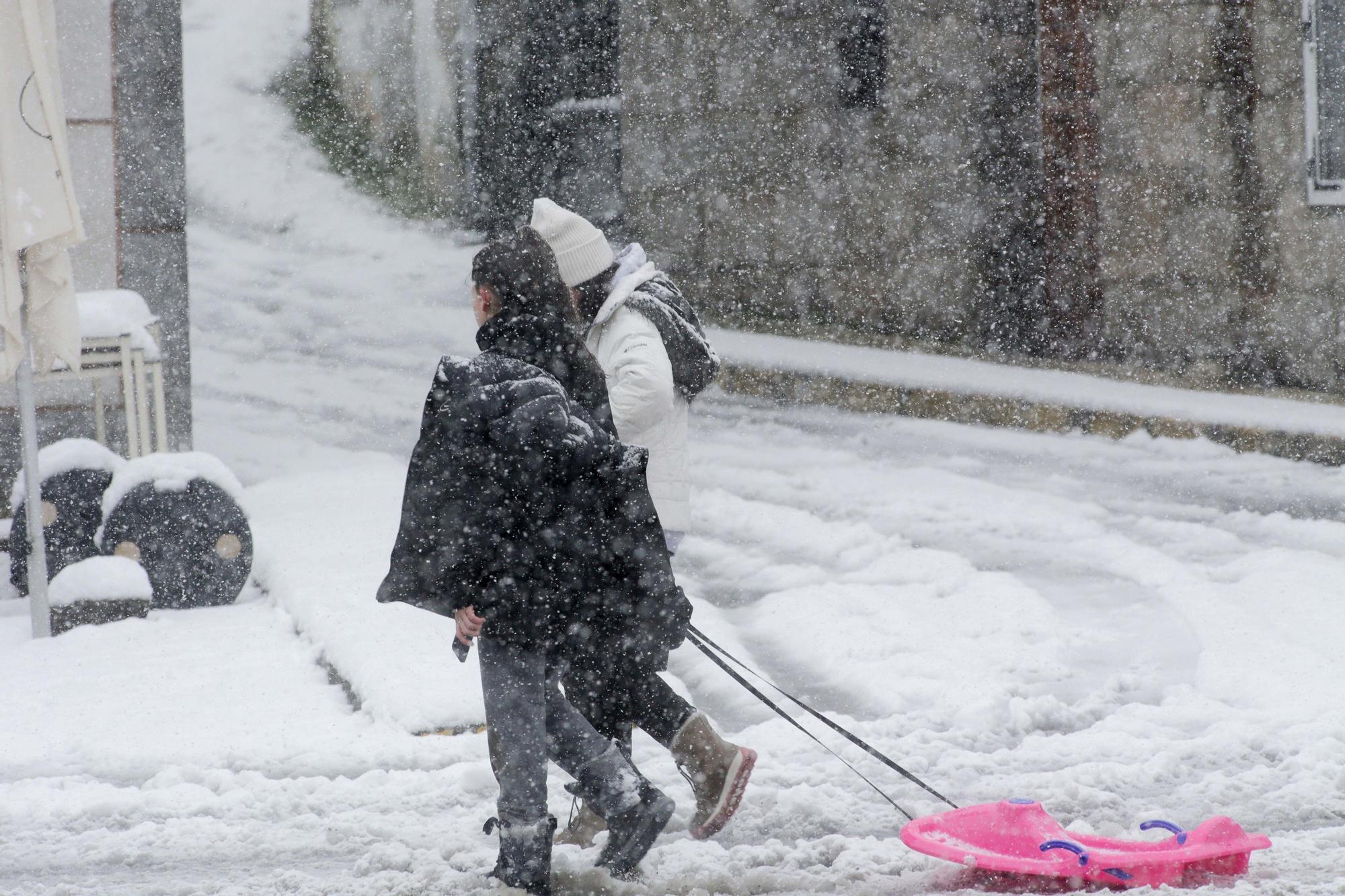 Dos personas caminan con un trineo por la nieve,