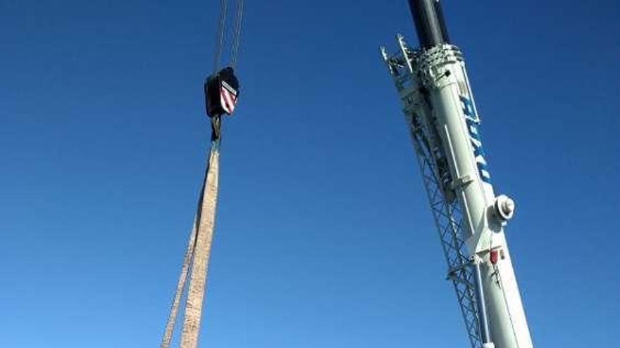 A la izquierda, miembros de la Sociedad de Amigos de Boal y operarios, tras colocar la roca; en el círculo, detalle de la instalación.