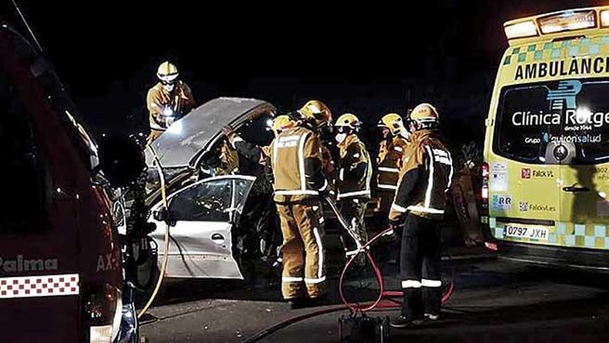 Varios bomberos, tras el siniestro junto al coche en el que viajaba la vÃ­ctima, en la autopista de s&#039;Arenal.