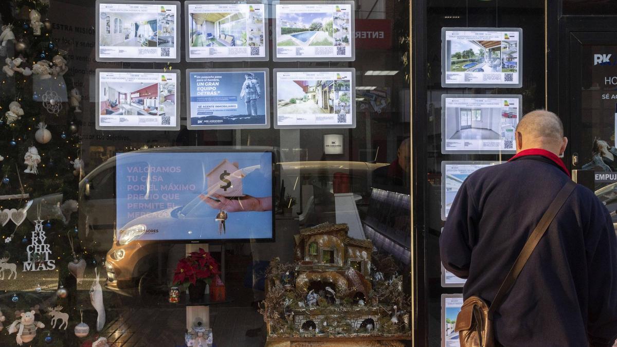 Un hombre observa el escaparate de una inmobiliaria en València.