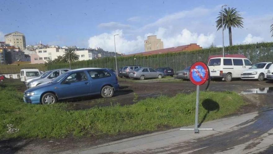 Varios coches aparcados en una parcela del entorno de A Maestranza.